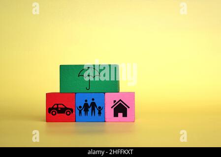 Insurance and protection concept. Wooden cubes with umbrella, car, family and house icon. Stock Photo