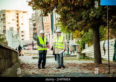 Two construction workers are walking together while talking Stock Photo