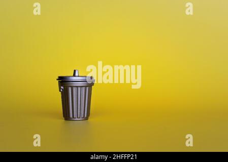 Close up image of trash can on yellow background with copy space Stock Photo