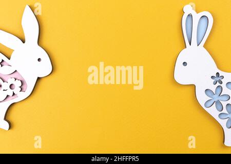 Easter rabbits on a yellow background, celebration border composition, flat lay, copy space and top view Stock Photo