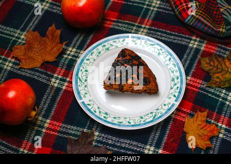 Brownie pie. Chocolate deesert on blue plate. Top view, a piece of sliced autumn pie with berries on vintage fall nature background texture. Top view Stock Photo