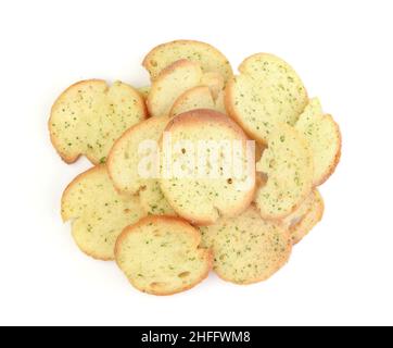 Heap of baked baguette crackers with herbs isolated on white. Top view. Stock Photo