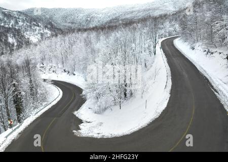 A sharp turn on a winding road in the forest. KARTEPE, KOCAELI, TURKEY. Beautiful winter landscape aerial view. Stock Photo