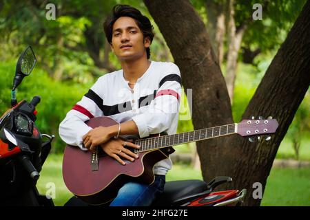 boy with red guitar with red biike Stock Photo