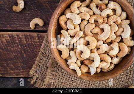 Tasty cashew nuts in bowl on wooden table. Top view, overhead Stock Photo