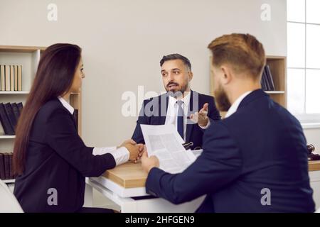 Family lawyer giving consultation to couple concerning divorce settlement agreement Stock Photo