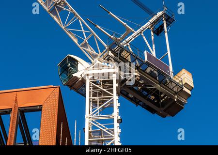 Architect plan on working table with crane and building construction background Stock Photo