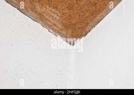 Repair of the joint of the two white plaster walls corner at the ceiling, the connecting link, construction work. Stock Photo