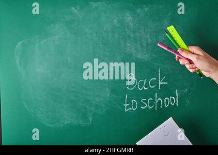 Female teachers hand writing on school board back to school white chalk. Concept back to school. Mock up for design. Copy space. Education Concept. Stock Photo