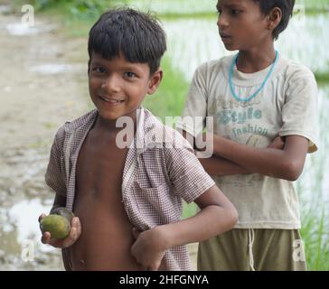 Happy Poor kids havind mango Stock Photo