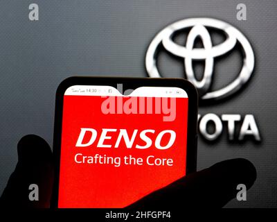 Ukraine. 16th Jan, 2022. In this photo illustration, the Denso Corporation logo is seen displayed on a smartphone screen with the Toyota logo in the background. (Credit Image: © Igor Golovniov/SOPA Images via ZUMA Press Wire) Stock Photo