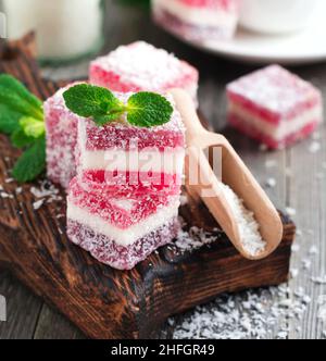 Fruit color marmalade with coconut on the old wooden background. Selective focus. Stock Photo