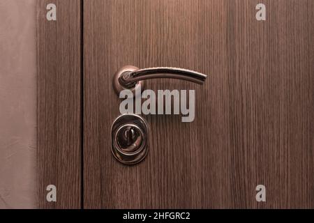 Steel doorknob opening or closing the entrance or exit of the house close-up. Stock Photo
