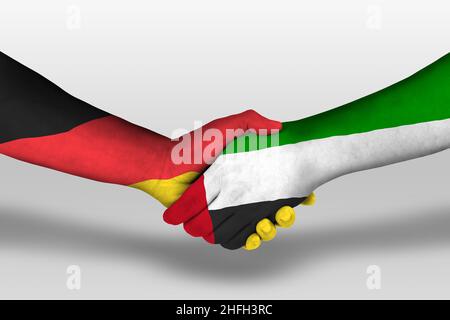 Handshake between united arab emirates and germany flags painted on hands, illustration with clipping path. Stock Photo