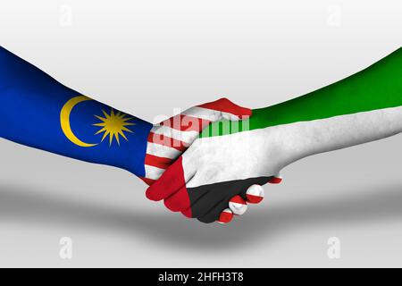 Handshake between united arab emirates and malaysia flags painted on hands, illustration with clipping path. Stock Photo