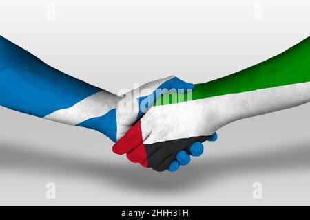 Handshake between united arab emirates and scotland flags painted on hands, illustration with clipping path. Stock Photo