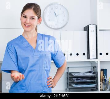 Female doctor making welcome gesture Stock Photo