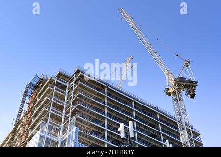 London, England - June 2020: Tower crane on the side of a tall new building under construction Stock Photo