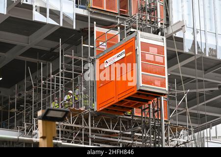 London, England - June 2020: Construction workers waiting to get into a lift on the outside of of a new building under construction in central London Stock Photo