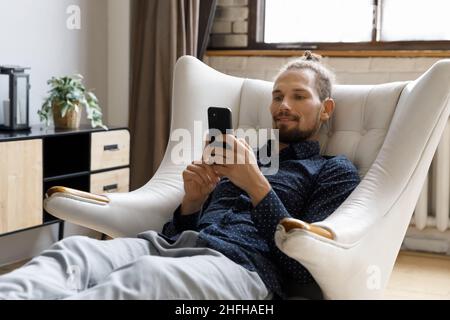 Happy handsome young hipster man using cellphone apps. Stock Photo