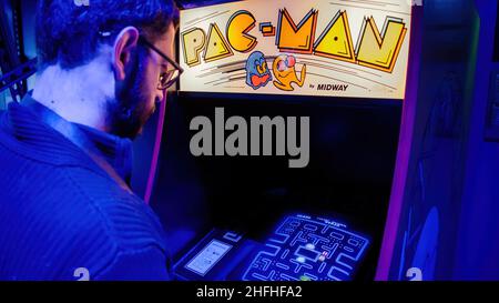 Istanbul, Turkey - February 2016: Man playing with pac-man arcade console machine cabinet Stock Photo