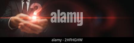 Business question panoramic banner with copy space, businessman holding big question mark, selective focus Stock Photo