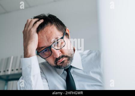 Regretting bad business decision, disappointed businessman in office, selective focus Stock Photo