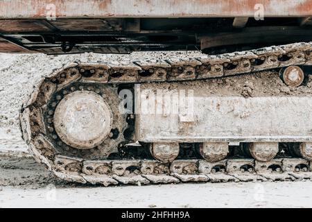 Crawler excavator undercarriage close-up. Bulldozer working on construction site or quarry. Mining machinery moving clay, smoothing gravel surface for Stock Photo