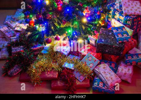 Wrapped Christmas presents under an artificial Christmas tree. Stock Photo