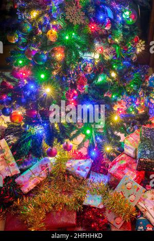 Wrapped Christmas presents under an artificial Christmas tree. Stock Photo