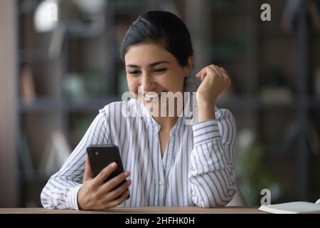 Happy young Indian woman using cellphone. Stock Photo