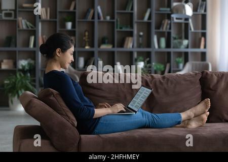 Happy young Indian woman working with document on computer. Stock Photo