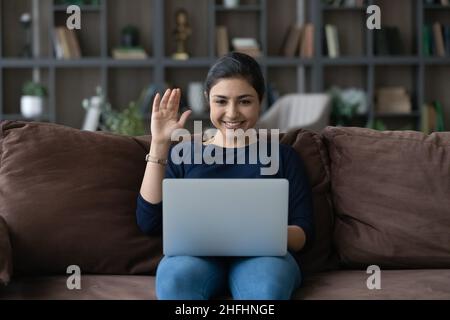 Smiling attractive young Indian woman starting video call. Stock Photo