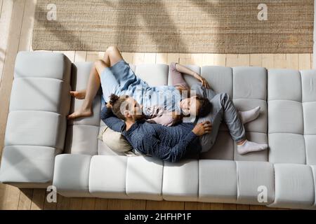 Relaxed smiling bonding young family couple communicating at home. Stock Photo