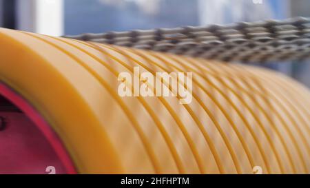 Close up of rotating yellow cylinder with abrasive blades for cutting concrete blocks. Concept of new technologies in machinery and construction. Stock Photo