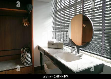 Hotel bathroom interior with sink, mirror and wardrobe cupboard. Stock Photo