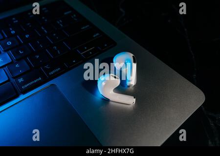 Barcelona, Spain - January 2022. New airpods pro on apple laptop. Wireless compact headphones. Music, technology, electronics concept Stock Photo