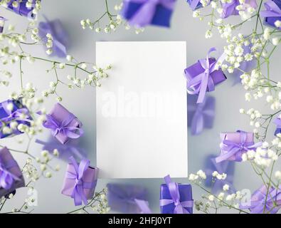 A multi-layered postcard made of gift boxes in a fashionable, trendy very peri color with white flowers on a foggy background. Happy women day and Val Stock Photo