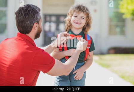 Funny nerd. Father supports and motivates son. Kid going to primary school. Kids education. Smart wunderkind in school uniform ready to school. Stock Photo