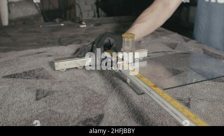 Glass cutting and processing for fireplace doors. Circular glass cutter. Worker cut glass with glass cutting diamond. Stock Photo