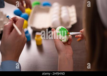 Mother and daughter paint Easter eggs. Preparation of decorations for Easter, creativity with children, traditional symbols. Preparation for Easter. h Stock Photo