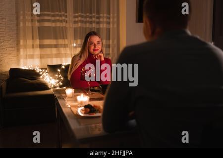 Romantic dinner for two, lovers celebrate valentine's day, couple having dinner at home by candlelight, man and woman having a date with wine, valenti Stock Photo