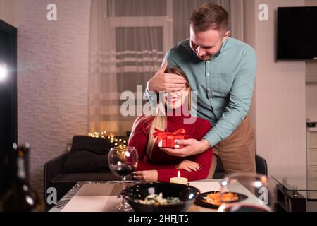 Romantic date, valentine's day festive dinner for two, surprise gift for a holiday or birthday to a woman from a man, romantic relationship concept Stock Photo