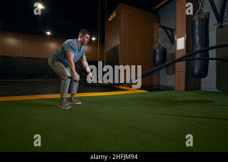 Focused young sportsperson training in fitness room Stock Photo