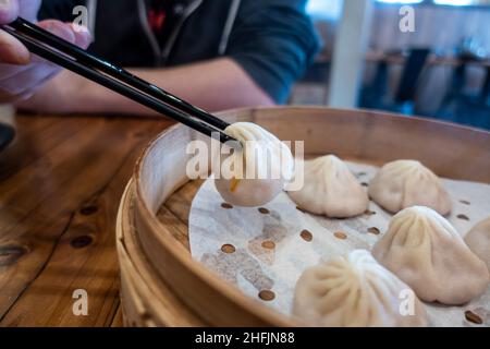 Close up view of xiao long bao in a steamer basket inside a restaurant Stock Photo