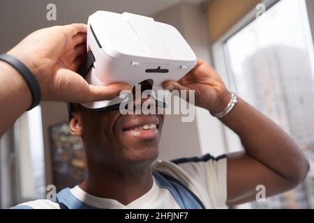 Person holding VR glasses close to his eyes at home Stock Photo