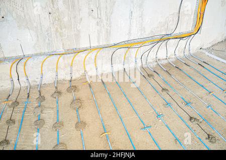 Laying of heating cable in the construction of underfloor heating. Heating of concrete floor. Construction technologies. Stock Photo