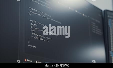 Closeup of computer display of software developer typing database functions script in it startup agency. Display concept of programer writing source code. Scrolling text of programming language. Stock Photo