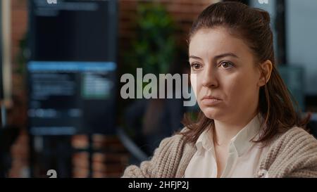 Portrait of caucasian software developer working focused looking at computer screen while typing in it startup office. System engineer writing code with colleagues online cloud computing. Stock Photo