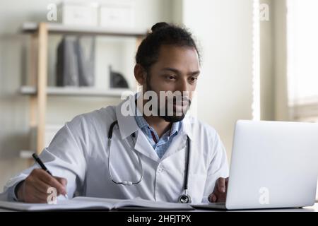 Focused young African American doctor working in office. Stock Photo